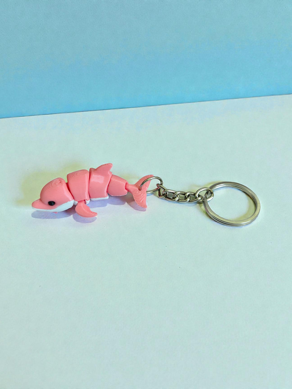 3D Printed white and pink flexi dolphin keychain